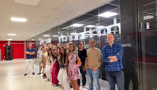 Grupo de visitantes posando junto a los servidores de Nasertic