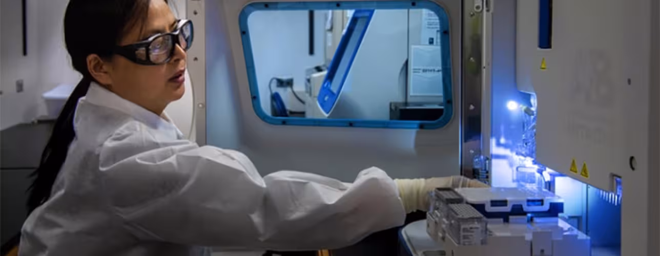 Técnica con traje y gafas protectores manipula máquina