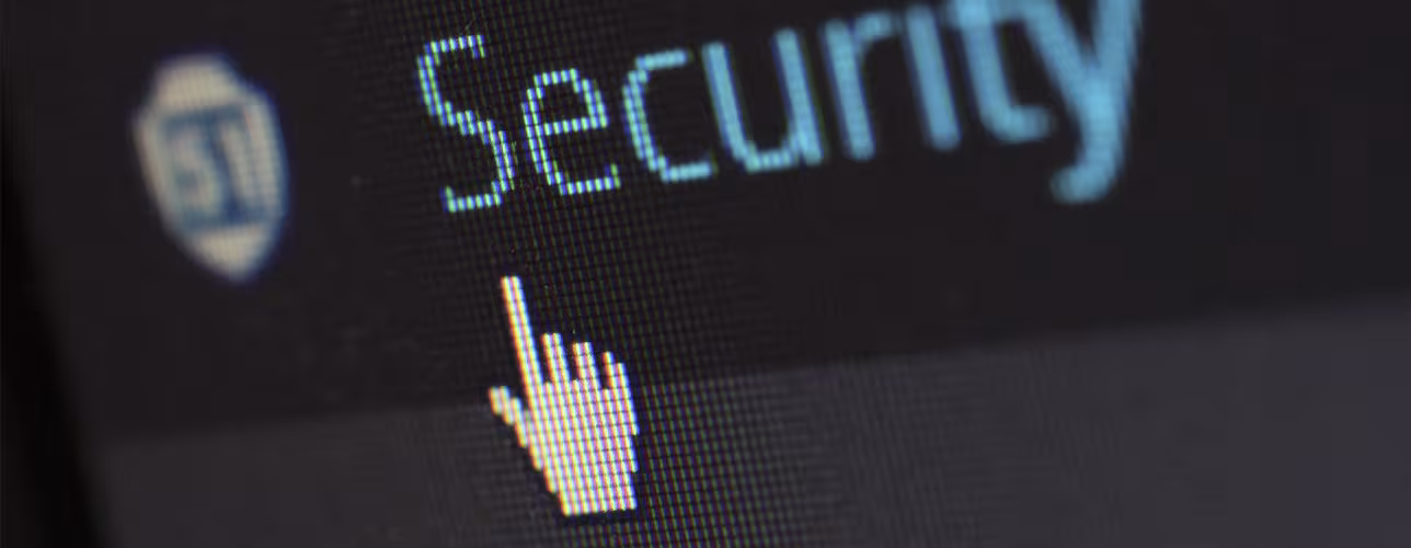 Primer plano de una pantalla mostrando la palabra “Security”, un icono de escudo y un cursor de mano señalando el texto.